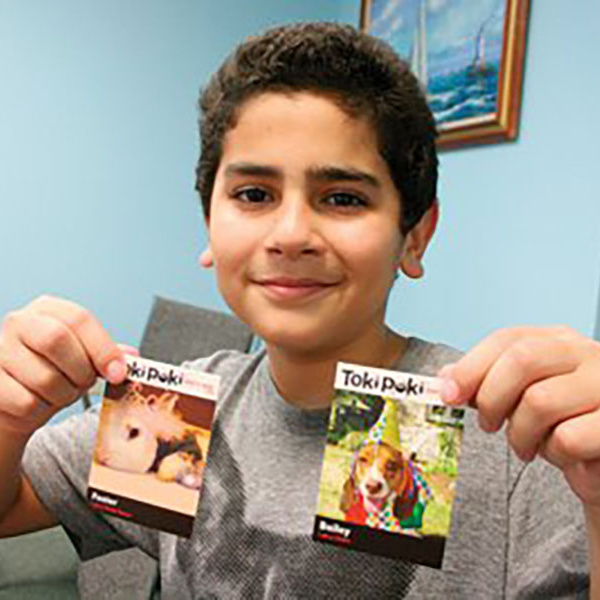 Ryan Agnew with his pets' Toki Poki Trading Cards